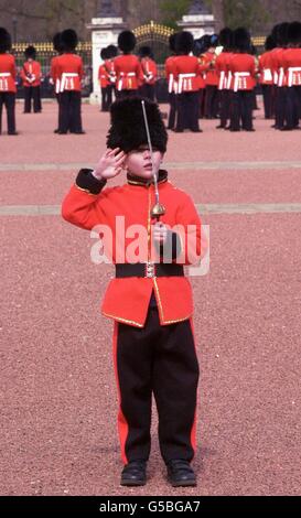 Matthew Swallow, sechs, trägt stolz eine Gardeuniform auf dem Vorplatz des Buckingham Palace - der offiziellen Londoner Residenz der britischen Königin Elizabeth II - während die Zeremonie der Wachablösung hinter ihm weitergeht. *... Matthew aus Potters Bar, Hertfordshire, war vor dem Palast und wartete darauf, als Teil eines Schulprojekts fotografiert zu werden, als ihn königliche Beamte entdeckten und ihn für eine Tribünenansicht nach innen brachten. Stockfoto