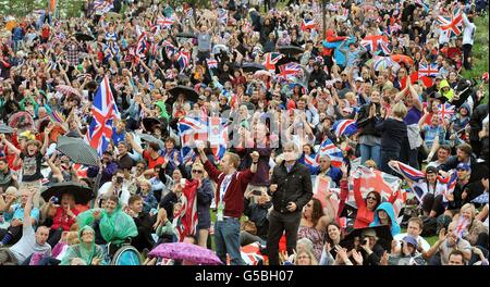 Eine große Gruppe von Fans feiert die erste Goldmedaille, die von Team-GB-Rudern gewonnen wurde, nachdem sie sie auf riesigen Bildschirmen im Olympic Park in Stratford im Osten Londons gesehen hat. Stockfoto