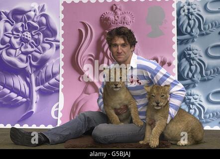 Der Schauspieler Jonathan Cake, der in dem demnächst erscheinenden Film Biggles zu sehen ist, mit Lion Cubs Ben bei der Vorstellung der St. George's Day-Ausgabe neuer Royal Mail-Briefmarken am Hauptsitz von Consignia (ehemals The Post Office) im Zentrum von London. *...das am 23. April 2001 veröffentlichte Set zeigt den gekrönten Löwen Englands (1. Klasse), die englische Rose und die drei Löwen Englands (2. Klasse, nicht abgebildet). Stockfoto