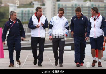 Premierminister David Cameron (zweiter links) geht mit (von links nach rechts) RYA Performance Director John Derbyshire, Herren Finn Gold Medaillengewinner Ben Ainslie, Men's Star Silver Medaillengewinner Andrew Simpson und Olympic Sailing Manager Stephen Park auf dem Ponton in Weymouth und Portland vor dem Männer RS-X Medal Race, Während des Tages elf der Olympischen Spiele 2012 in London. Stockfoto