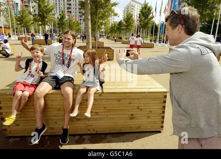 Kronprinz Frederick von Dänemark (rechts) macht ein Foto mit seinem Telefon von seinen Kindern Prinz Christian und Prinzessin Isabella, während sie auf beiden Seiten des dänischen Athleten Mikkel Hansen sitzen, während sie das London 2012 Olympic Athletes Village in Stratford, Ost-London besuchen. Stockfoto