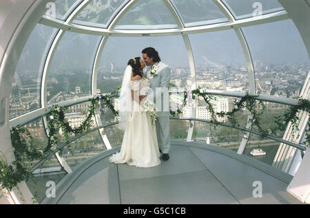 Simon Stapleton, 31, und Dawn Bottomley, 26, nachdem sie ihre Gelübde in einer der Hülsen des Millennium Eye, 450 Meter über London, ausgetauscht hatten. Das Paar aus Burgess Hill, West Sussex, war das erste Paar, das am Steuer verging. * nach dem Gewinn eines Wettbewerbs auf dem morgendlichen Fernsehprogramm GMTV. Die 15-minütige standesamtliche Zeremonie, die von dem Lambeth-Superintendent-Registrar Richard Edwards durchgeführt wurde, fand an dem vermutlich wärmsten Tag des Jahres statt und überblickte die spektakuläre Aussicht auf London. Stockfoto