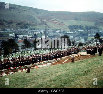 ABERFAN 1966: Eine allgemeine Ansicht auf dem Friedhof während der Beerdigung von 82 Katastrophenopfern - 81 davon Kinder - die starben, als eine Masse von Kohlenschlämme ihre Schule überflutete. Im Vordergrund ist ein Kranz in Form der Pantglas Junior School, wo die Opfer starben. Stockfoto