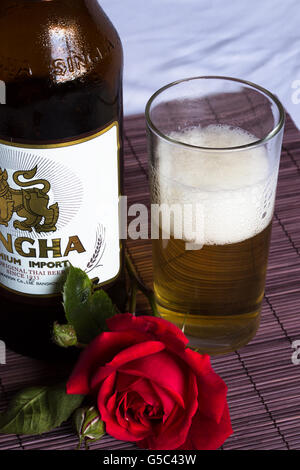 Abstrakte Sicht auf eine kalte Flasche Thai Bier, Singha, teilweise in ein Glas genommen in Durham, England gegossen. Stockfoto