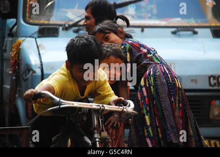 Jungen und Mädchen, die eine Menge Spaß beim Spielen auf einem Fahrrad, Kolkata, Westbengalen, Indien Stockfoto