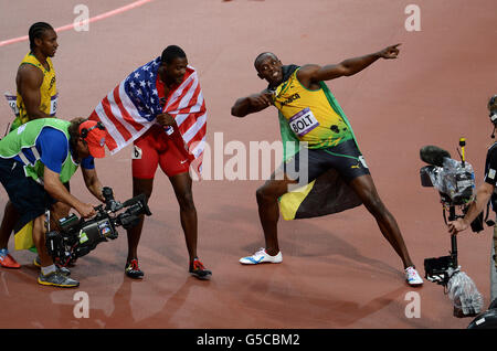 Jamaikas Usain Bolt feiert den Sieg im 100-m-Finale der Männer, das der zweitplatzierte Jamaikas Yohan Blake (links) und der drittplatzierte US-Amerikaner Justin Gatlin am neunten Tag der Olympischen Spiele in London 2012 im Olympiastadion angeschaut haben. Stockfoto