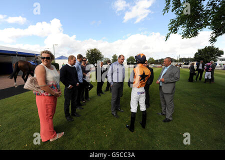 Jockey Martin Leonard spricht mit Trainer von Barathea Dancer, Roger Teal (Center) im Paradering auf der Rennbahn Epsom Downs Stockfoto