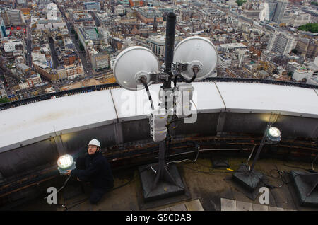 BT Aerial Rigger Mark Gravett passt das Licht auf dem in Gold beleuchteten BT Tower im Zentrum von London an, um die Athleten des Teams GB zu markieren, die die Anzahl der Goldmedaillen überholen, die 2008 bei den Olympischen Spielen in Peking gewonnen wurden. Stockfoto