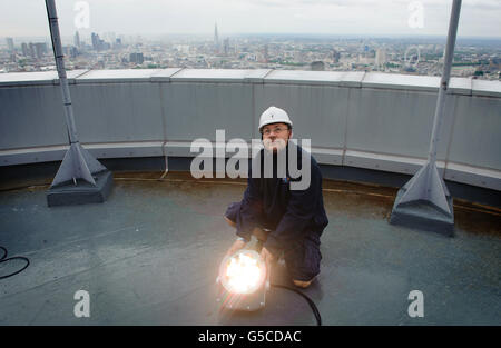 BT Aerial Rigger Mark Gravett passt das Licht auf dem in Gold beleuchteten BT Tower im Zentrum von London an, um die Athleten des Teams GB zu markieren, die die Anzahl der Goldmedaillen überholen, die 2008 bei den Olympischen Spielen in Peking gewonnen wurden. Stockfoto