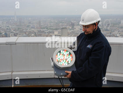 BT Aerial Rigger Mark Gravett passt das Licht auf dem in Gold beleuchteten BT Tower im Zentrum von London an, um die Athleten des Teams GB zu markieren, die die Anzahl der Goldmedaillen überholen, die 2008 bei den Olympischen Spielen in Peking gewonnen wurden. Stockfoto