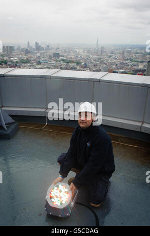 BT Aerial Rigger Mark Gravett passt das Licht auf dem in Gold beleuchteten BT Tower im Zentrum von London an, um die Athleten des Teams GB zu markieren, die die Anzahl der Goldmedaillen überholen, die 2008 bei den Olympischen Spielen in Peking gewonnen wurden. Stockfoto