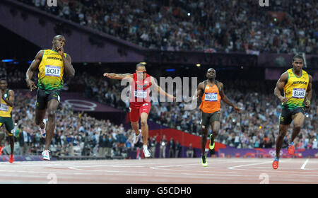 Jamaikas Usain Bolt (links) überquert die Linie, um im 200-m-Finale der Männer mit Teamkollege Yohan Blake (rechts), US-amerikanischer Spearmon Wallace (2. Links) und Netherlands Churandy Martina (2. Rechts) im Olympiastadion in London die Goldmedaille zu gewinnen. Stockfoto