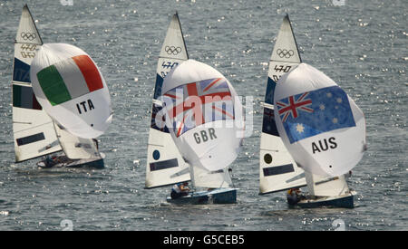 Die britischen Silbermedaillengewinner Luke Patience und Stuart Bithell verfolgen das australische Goldmedaillengewinner-Team von Mathew Belcher und Malcolm Page während des 470-Klassen-Medaillenrennens der Männer bei den Olympischen Spielen in Weymouth und Portland. Stockfoto