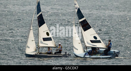 Die Briten Luke Patience und Stuart Bithell (rechts) versuchen, das australische Team vor der Waffe beim Medal Race in der Klasse der Männer 470 bei den Olympischen Spielen in Weymouth und Portland über die Startlinie zu zwingen. Australien gewann Gold, GB gewann Silber. Stockfoto