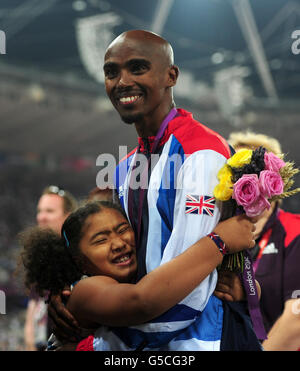 Großbritannien Mo Farah und seine Tochter Rihanna mit einer Goldmedaille nach dem Sieg im Männer-Finale über 5000 m am 15. Tag der Olympischen Spiele in London im Olympiastadion in London. Stockfoto