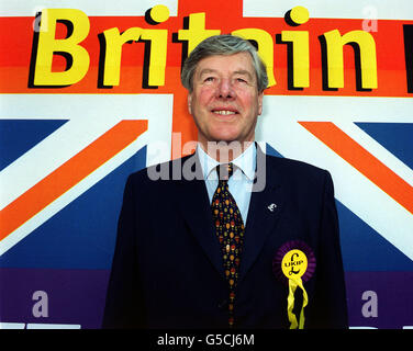 Der Führer der UK Independence Party (UKIP), Jeffrey Titford, durch ein Plakat für die Partei vor der methodistischen Central Hall im Zentrum von London, wo die UKIP eine Generalwahlveranstaltung abhielt. Stockfoto