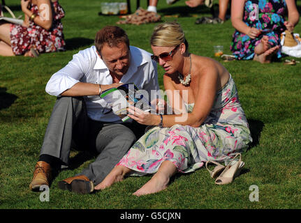 Pferderennen - Renn- und Musiknacht - Rennbahn Lingfield Park. Rennfahrer genießen die Sonne im Lingfield Park. Stockfoto