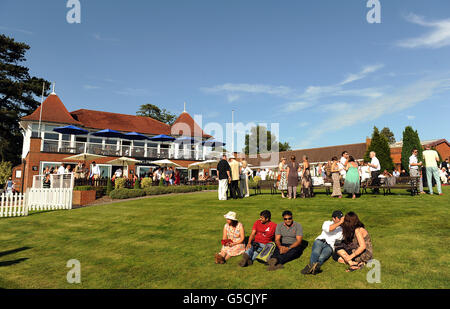 Pferderennen - Renn- und Musiknacht - Rennbahn Lingfield Park. Rennfahrer genießen die Sonne im Lingfield Park. Stockfoto