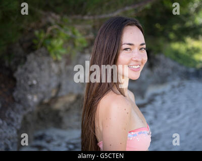 Junge schöne Mischlinge Frau am Strand im Bikini lächelnd Stockfoto