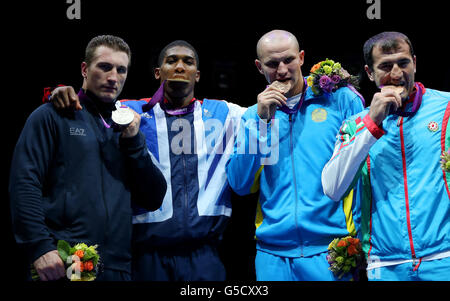 Der britische Anthony Joshua feiert am 16. Tag der Olympischen Spiele im Excel, London, mit seiner Goldmedaille zusammen mit dem Silbermedaillengewinnerin Roberto Cammarelle (links) aus Italien und dem Bronzemedaillengewinnerin Adilbek Niyazymbetov aus Kasachstan und dem russischen Egor Mekhontcev (rechts). Stockfoto