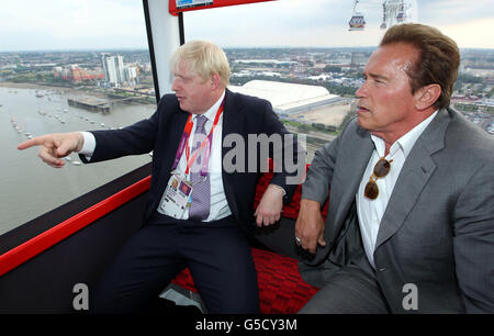 Bürgermeister Boris Johnson (links) und Arnold Schwarzenegger fahren mit der Emirates-Seilbahn von Greenwich zum Excel in den Docklands, nachdem sie den olympischen Basketball in Greenwich beobachtet haben. Stockfoto