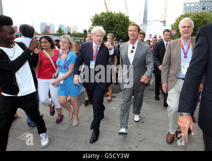 Bürgermeister Boris Johnson (Mitte links) mit Arnold Schwarzenegger, als sie mit der Emirates-Seilbahn von Greenwich zum Excel in den Docklands fahren, nachdem sie den olympischen Basketball in Greenwich beobachtet haben. Stockfoto