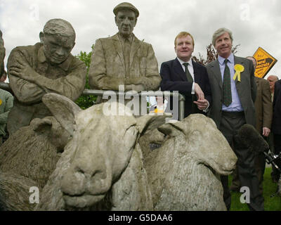 Der Vorsitzende der Liberaldemokratischen Partei, Charles Kennedy, und der Kandidat des Parlaments für Torridge und West Devon, John Burnett, neben einer Statue von Bauern in Hatherleigh in West Devon, im Vorfeld der Parlamentswahlen am 7. Juni. * Herr Kennedy griff heute Labours Manifest zum "Moorstandard" an und brandmarkte die Pläne der Tories "voller Löcher", als er ein Maßnahmenpaket enthüllte, um den bedrängten britischen Landwirten zu helfen, einschließlich eines 100-Millionen-Notfallentschädigungsfonds. Stockfoto