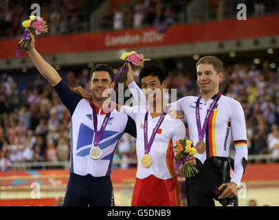 Der britische Mark Lee Colbourne feiert den Gewinn einer Medaille mit Goldmedaille mit dem chinesischen Zhang Yu Li (Mitte) und dem Bronzemedaillengewinnerin Tobias Graf (rechts) während des 1 2-3-km-Zeitfahrens der Männer auf dem Velodrome im Olympic Park in London. Stockfoto