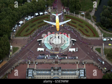 Ein Airbus-Flugzeug von British Airways fliegt während der Londoner Siegesparade 2012 über das Queen Victoria Memorial am Buckingham Palace für die Athleten des Teams GB und der Paralympischen GB in London. Stockfoto