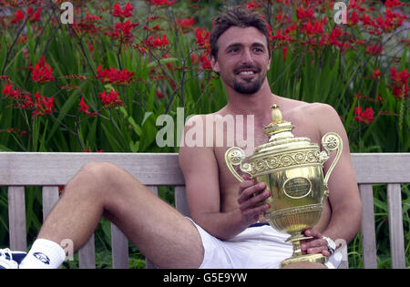 KEINE KOMMERZIELLE NUTZUNG: Goran Ivanisevic aus Kroatien feiert mit der Trophäe, nachdem er Australiens Pat Rafter beim Herrenfinale der 2001 Lawn Tennis Championships in Wimbledon, London, Montag, 9. Juli 2001 besiegt hat. Ivanisevic gewann 6-3, 3-6, 6-3, 2-6, 9-7 . Stockfoto