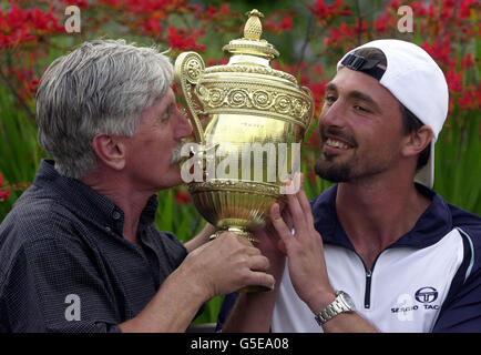 Goran Ivanisevic aus Kroatien feiert mit seinem Vater Srdjan und die Trophäe, nachdem er den Australier Pat Rafter beim Herrenfinale der Lawn Tennis Championships 2001 in Wimbledon, London, besiegt hat. Ivanisevic gewann 6-3, 3-6, 6-3, 2-6, 9-7 . Stockfoto