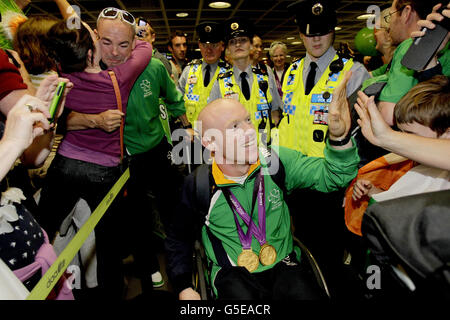 Der irische Athlet und Doppel-Goldmedaillengewinnerin Mark Rohan (rechts) und Enda Smith Cyclist (links) kommen nach den Paralympischen Spielen in London 2012 wieder am Flughafen Dublin an und werden nach dem fantastischen Medaillenransport des Teams bei den Spielen herzlich willkommen geheißen. Stockfoto