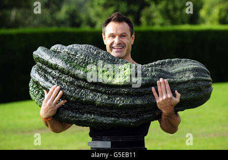 Der Gewichtheber Jonathan Walker von Harrogate hebt ein Mark mit einem Gewicht von 119 kg 12 oz über seinen Kopf, nachdem es die Giant Marrow Class in der Harrogate Autumn Flower Show gewonnen hatte. Das Mark wurde von Peter Glazebrook aus Newark angebaut, der sechs erste Preise in den Giant Vegetable Classes auf der Show erhielt. Stockfoto