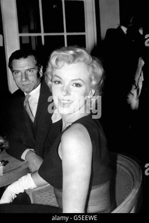 Marilyn Monroe aus Hollywood bei einer Pressekonferenz im Savoy Hotel, London. Im Hintergrund ist Sir Laurence Olivier, mit dem sie im neuen Film „der schlafende Prinz“ die Hauptrolle übernimmt. Stockfoto