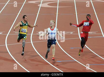 Der britische Jonnie Peacock (Mitte) überquert die Linie und gewinnt das 100-m-T44-Finale der Männer während der Paralympischen Spiele in London. Stockfoto