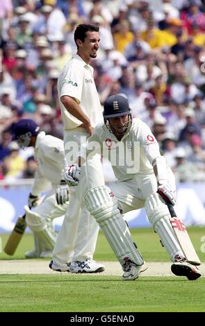 Die Engländer Mike Atherton und Mark Butcher haben beim ersten Testspiel in Edgbaston, Birmingham, die Runden vor dem Bowling des australischen Jason Gillespie (Mitte) gelegt. Stockfoto