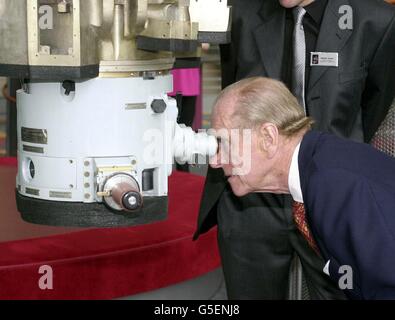 Der Herzog von Edinburgh blickt durch ein Periskop, beobachtet von George Bennett, dem Vorsitzenden des Wissenschaftszentrums, während des Besuches des Duke und Königin Elizabeth II. Im Wissenschaftsmuseum in Glasgow, Schottland. Stockfoto