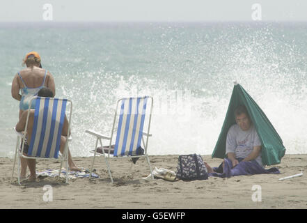 Touristen in Torremolinos an der Costa Del Sol. Britische Urlauber vermissen in Großbritannien rasende Gewitter, während in Spanien das Wetter nach den Regenschauern bedeckt war. Stockfoto