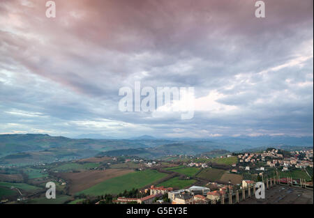 Italienische Landschaft. Provinz Fermo, Italien. Dorf auf einem Hügel unter dramatischen blauen Wolkenhimmel Stockfoto