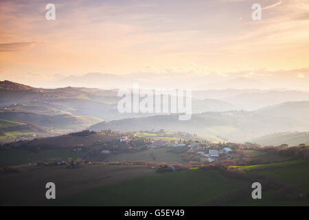 Morgen-Panorama der italienischen Landschaft. Provinz Fermo, Italien. Dörfer und auf Hügeln unter bunten bewölktem Himmel Stockfoto