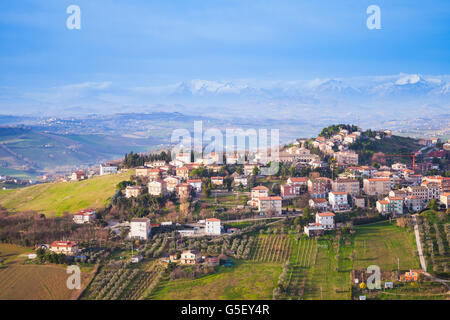 Helle ländliche Panorama der italienischen Landschaft. Provinz Fermo, Italien. Dorf auf einem Hügel unter blauen Wolkenhimmel Stockfoto