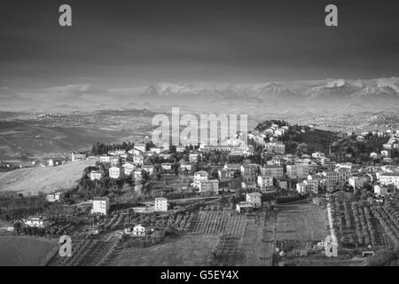 Ländliche Panorama der italienischen Landschaft. Provinz Fermo, Italien. Dorf auf einem Hügel unter dramatischen dunklen Himmel Stockfoto