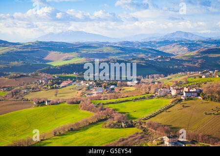 Ländliche Panorama der italienischen Landschaft. Provinz Fermo, Italien. Dörfer und Felder auf Hügeln unter blauen Wolkenhimmel Stockfoto