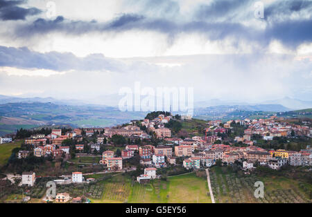 Ländliche Panorama der italienischen Landschaft. Provinz Fermo, Italien. Dorf auf einem Hügel unter dramatischen Wolkenhimmel Stockfoto