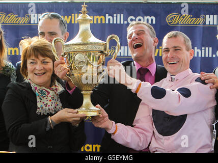 Kapitän Ramius Besitzer Clodagh McStay und Jockey Pat Smullen halten den William Hill Ayr Gold Cup, als Trainer Kevin Ryan lacht Stockfoto