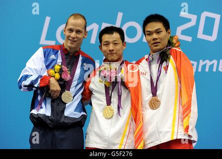 Der chinesische Qing Xu (Mitte) mit seiner Goldmedaille auf dem Podium, neben dem britischen Sascha Kindred (links) und seinem Silber und dem chinesischen Tao Zheng mit seiner Bronze nach dem 200-m-Ind.-Finale der Männer in Medley - SM6 im Aquatics Center im Olympic Park, London. Stockfoto