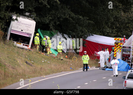 Rettungsdienste am Unfallort auf der A3 bei Hindhead in Surrey, wo drei Menschen starben und andere schwer verletzt wurden, als der Bus nach dem Zusammenprall mit einem Baum auf einem Damm umkippte. Stockfoto