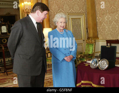 Königin Elizabeth II. Sieht das große Siegel des Reiches mit dem Großkanzler, dem rechthabenden Lord Irvine von Lairg, im Buckingham Palace, London. Das neue große Siegel, mit dem wichtige Staatsdokumente authentifiziert wurden, ist nur das zweite der langen Regierungszeit der Königin. * sein Vorgänger war seit 1953 im Einsatz und hatte sich so stark verschlissen, dass ein Ersatz in Auftrag gegeben wurde. Die Übergabe an Lord Irvine, die die Siegelbewahrerin ist, fand während einer Sitzung des Privy Council statt, als die Königin ihre formelle Genehmigung für das neue Design gab. Stockfoto