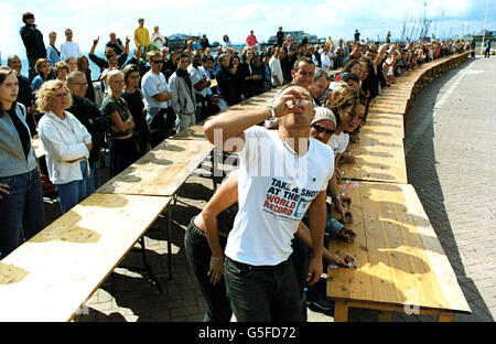 Der Big Brother-Räumer Josh Rafter (vorne, in der Mitte) startet am Brighton Beach einen Weltrekord-Wellenschlag. Der erfolgreiche Versuch markiert den Beginn des Gay Pride Festivals in Brighton. Stockfoto