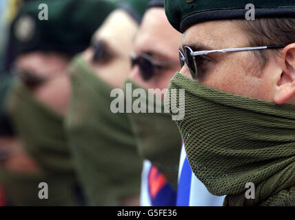 Maskierte UFF (Ulster Freedom Fighters) Männer zollen Jackie Coulter bei einem Wandbild ihrer Organisation Respekt. Coulter wurde in einer loyalistischen Fehde zwischen der UVF (Ulster Volunteer Force) und der UFF erschossen. * Tausende von Unterstützern marschierten durch die Shankill-Gegend von Belfast, bevor sie Kränze am Wandbild legten. Stockfoto